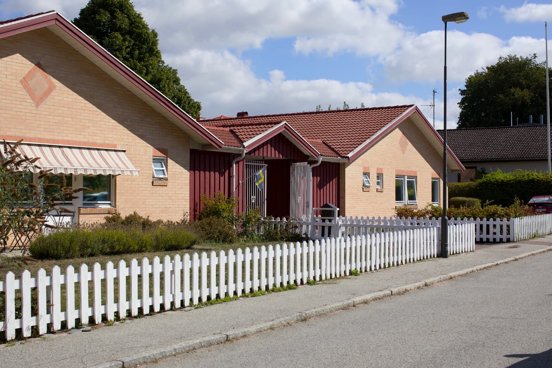 Bostadsbebyggelse med vitt staket i Malmö en sommardag